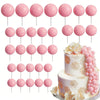 A set of pink foam cake toppers on sticks, including various round shapes and floral accents.