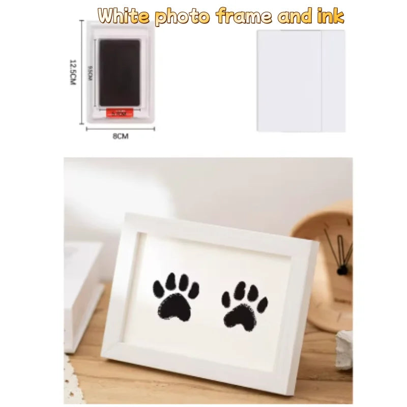 A white photo frame with a black paw print design, showing the frame and ink pad components.