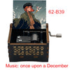 A hand-cranked wooden music box labeled 62-B39 featuring an illustration of a woman and decorative wood carving.