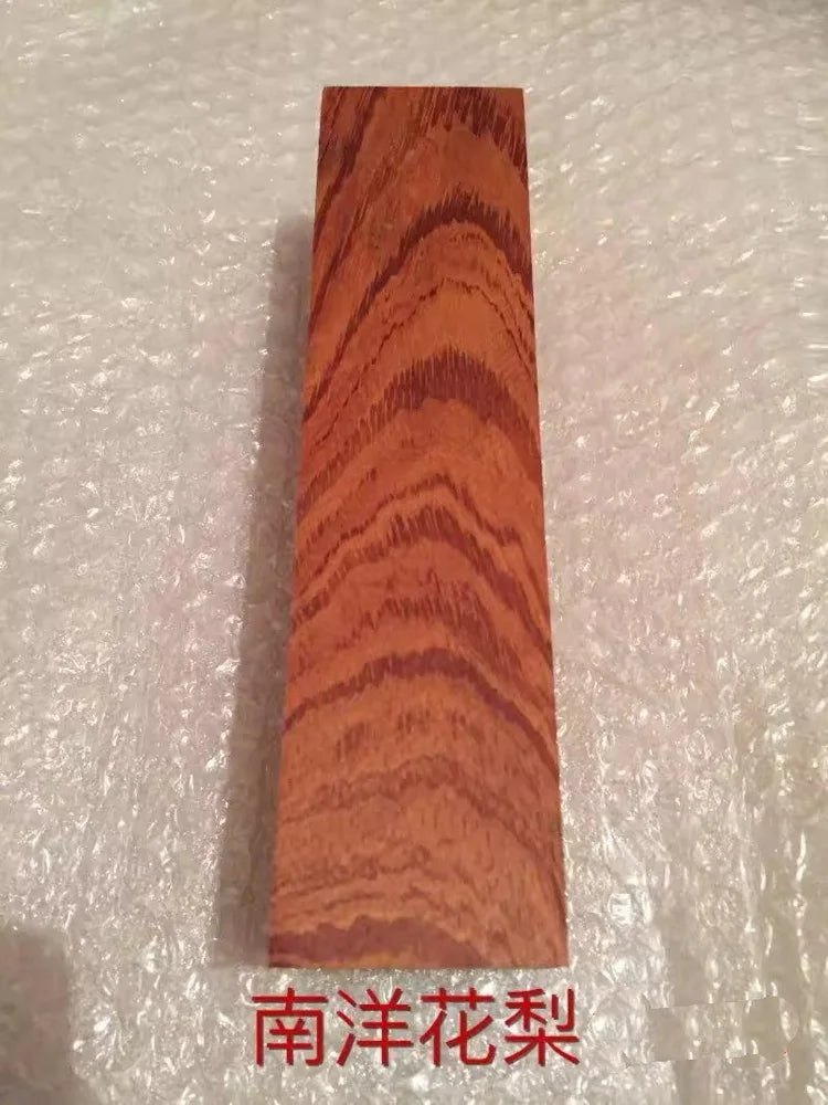 A vertical piece of reddish-brown wood with prominent, wavy grain patterns.