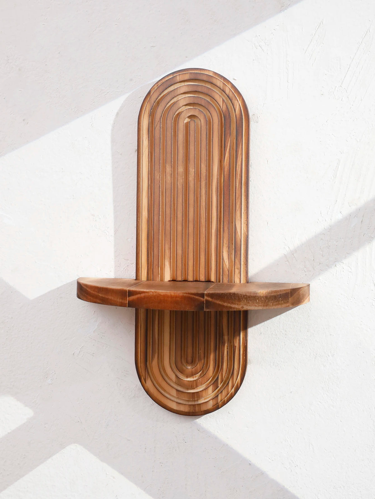 Two wooden, vertically ridged wall shelves mounted on a white wall.