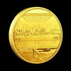 A round gold commemorative metal coin depicting a scene from the Last Supper.