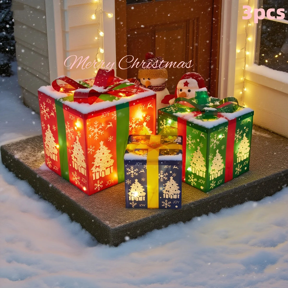 Three light-up Christmas gift boxes in red, green, and yellow colors displayed in a snowy outdoor setting.