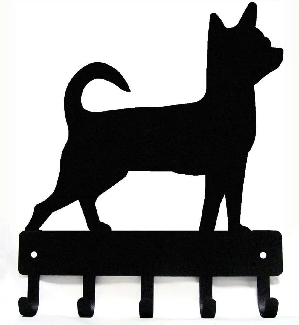Black silhouette of a cat standing on decorative metal key hooks for wall organization