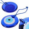 Blue glass evil eye amulet pendant with a white iris and black pupil on a blue background