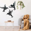 Black metal hummingbird wall decor set featuring various bird silhouettes displayed on a white wall.