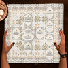 A white altar cloth with decorative borders and numbered sections for tarot divination tools