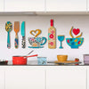 A set of rustic wooden kitchen wall decor featuring a fork, cup, and wine glass art displayed on a white cabinet shelf.