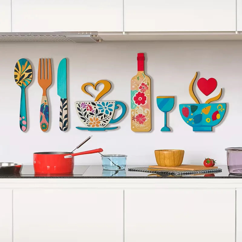 A set of rustic wooden kitchen wall decor featuring a fork, cup, and wine glass art displayed on a white cabinet shelf.