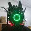 Primer plano de una máscara de juego cyberpunk iluminada con armadura negra y una luz circular verde brillante.