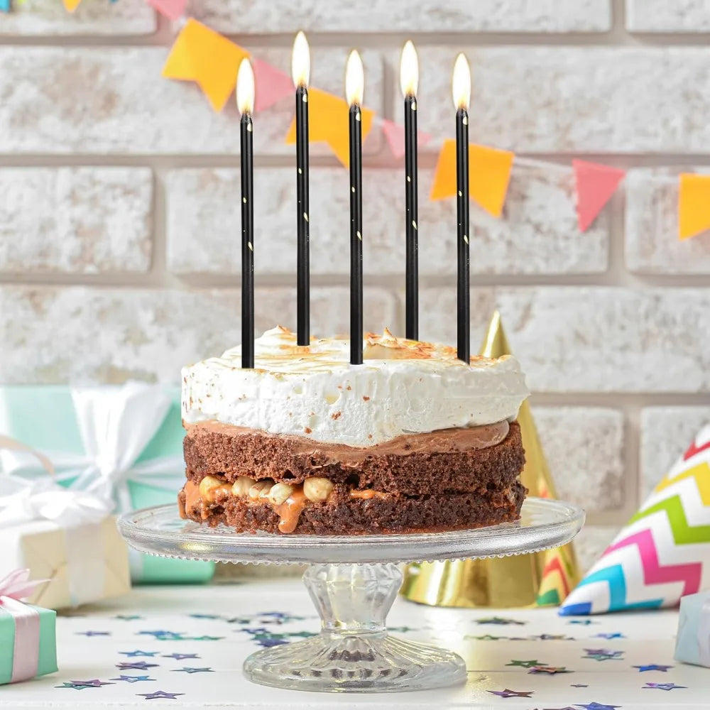 A set of twenty-four gradient blue metallic birthday candles displayed on a cake stand against a brick background.