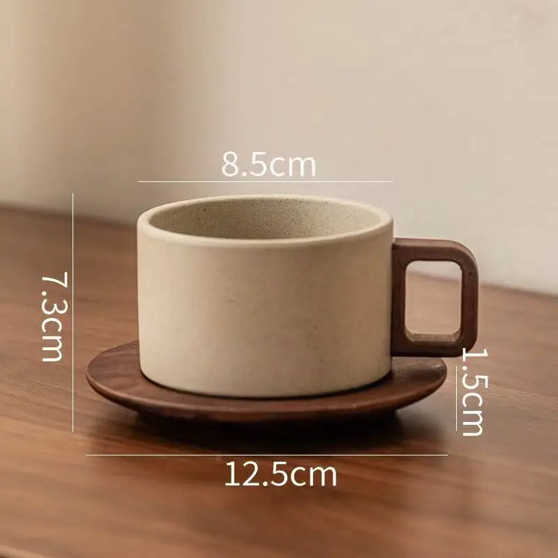 A beige ceramic coffee cup and saucer set shown on a wooden surface.