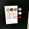 A collection of eight heart-shaped, checkered green and red fridge magnets displayed on a white background.