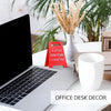 A red 3D printed letter sign saying I love you is placed on a white office desk next to a laptop and greenery.