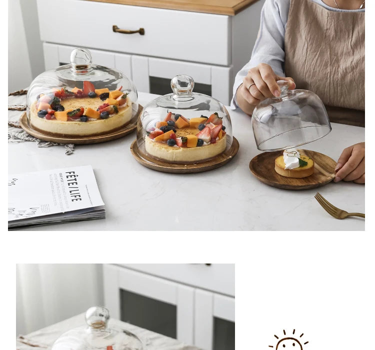A solid acacia wood cake tray with a glass dome cover is displayed on a white table.