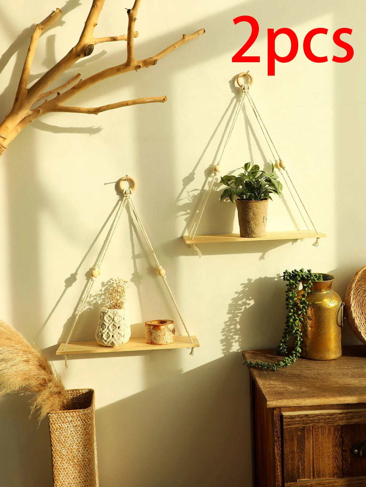 Two macrame wood floating wall shelves with hanging rope displaying plants and decorative items on a light-colored wall.
