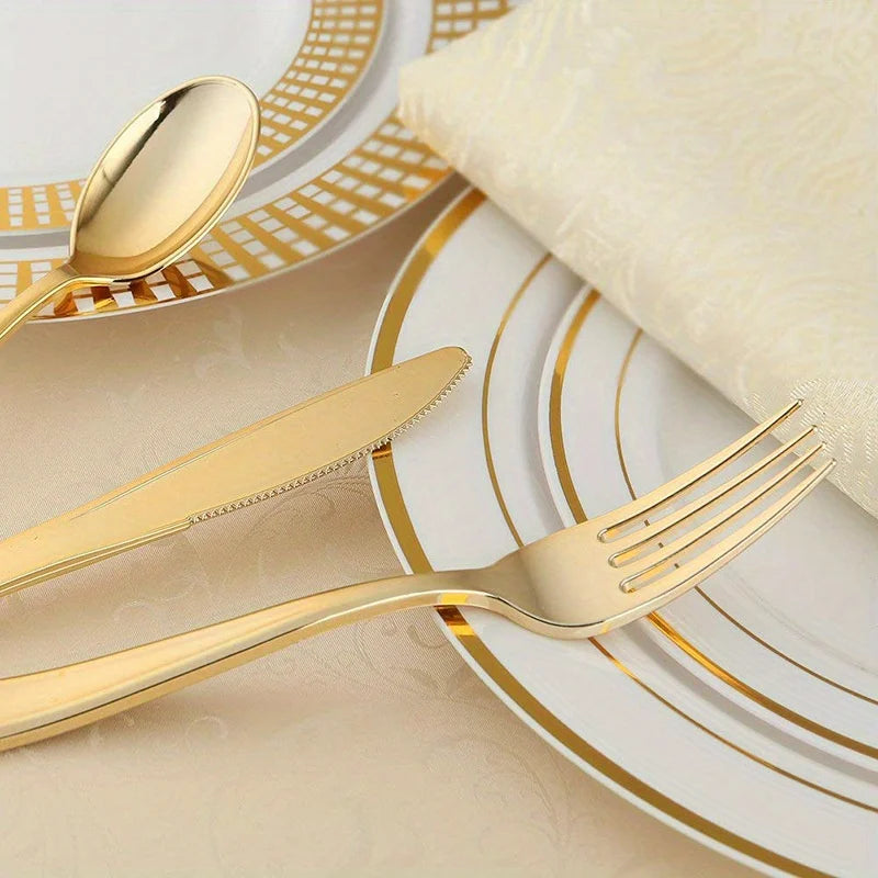 A set of gold disposable cutlery including forks, spoons, and knives arranged on a white plate.