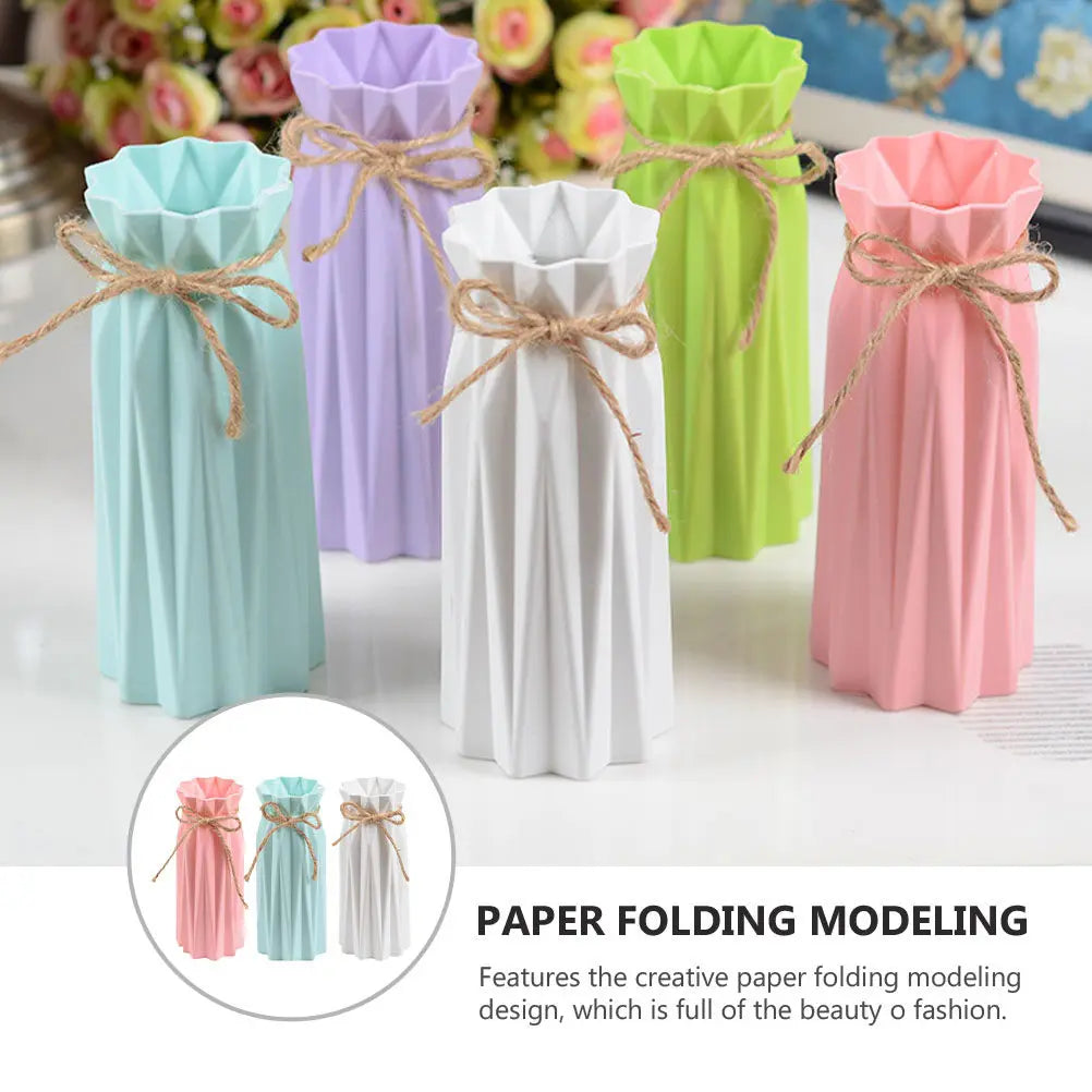 A collection of modern origami plastic vases in pastel colors including mint green, lavender, white, and pink.