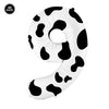 A white foil balloon shaped like the number nine with a black cow print pattern.