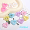 A collection of multi-color heart-shaped acrylic charms on a white background.