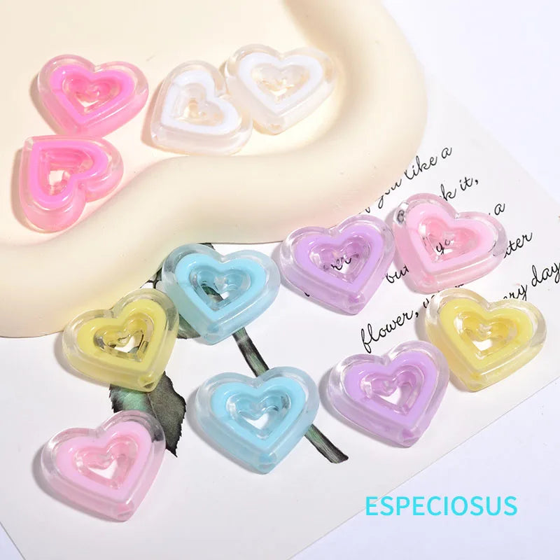 A collection of multi-color heart-shaped acrylic charms on a white background.