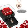 Un coffret cadeau avec une rose rouge conservée et un collier cœur en or.
