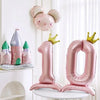 Pink aluminum foil crown number balloons shaped like the numbers 1 and 0 with a bunny decoration