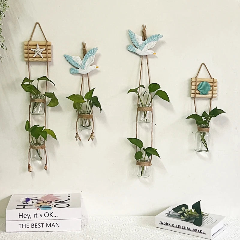 A collection of decorative glass terrariums hanging on a white wall with green plants.