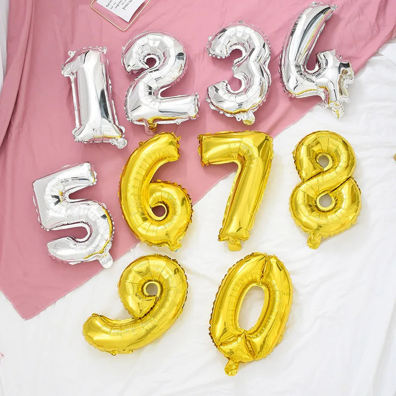 A collection of rose gold and silver gradient foil balloons forming the numbers 1, 2, 3, 4, 5, 6, 7, and 8, arranged on a whi