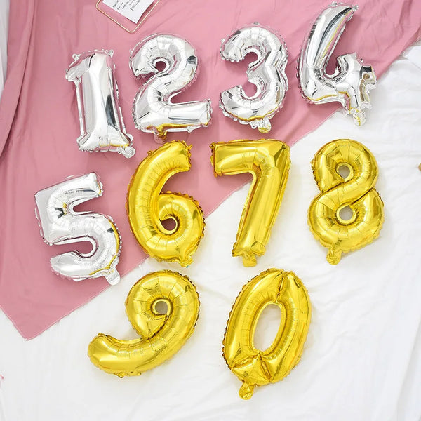 A collection of rose gold and silver gradient foil balloons forming the numbers 1, 2, 3, 4, 5, 6, 7, and 8, arranged on a whi