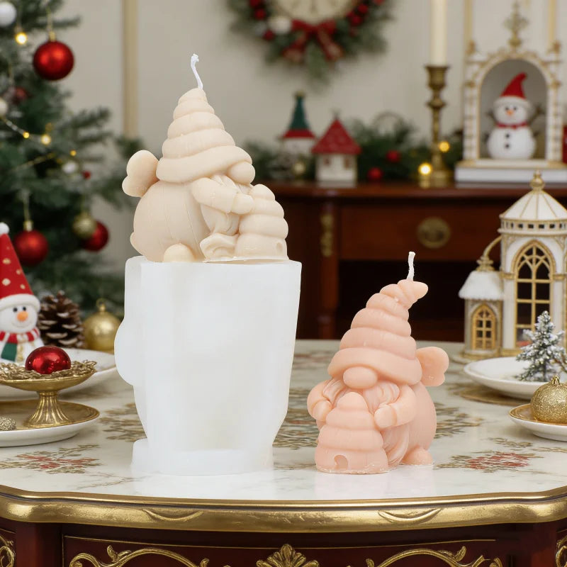 A pink silicone candle mold shaped like a gnome with a honeycomb hat, displayed on a white ceramic holder.