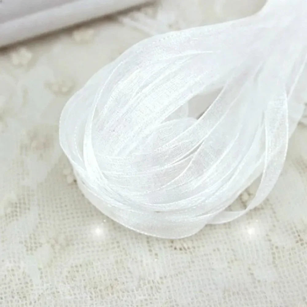 White decorative fishtail yarn ribbon coiled and flowing on a light surface.