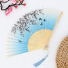 A vintage bamboo folding fan with light blue and white fabric and a natural straw handle.