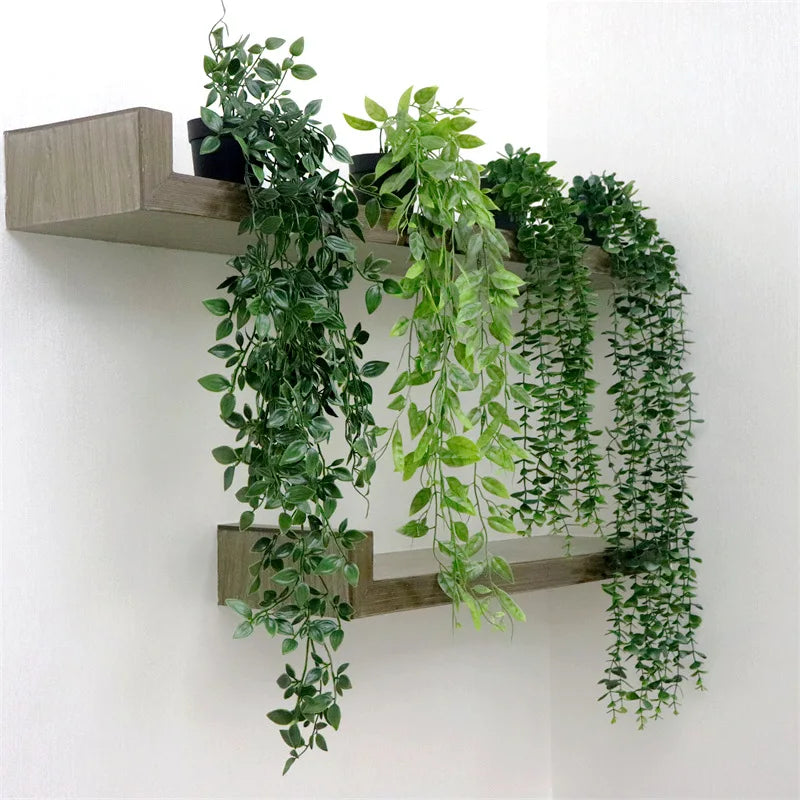 A set of four artificial eucalyptus hanging vines displayed on a wooden shelf.