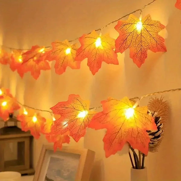 Warm orange maple leaf fairy string lights hanging on a wall.