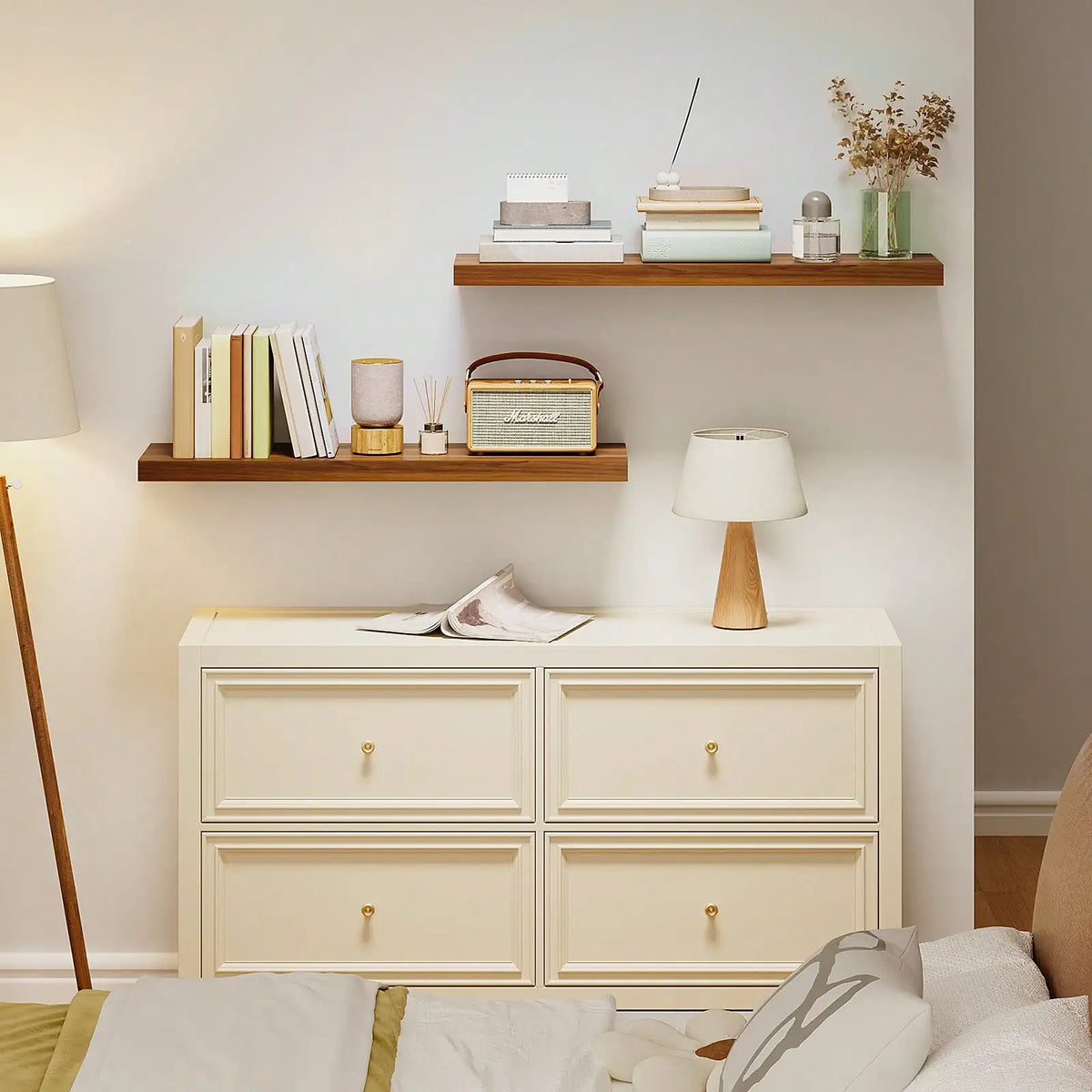 A set of two light wood floating wall shelves mounted on a white wall above a cream-colored dresser.