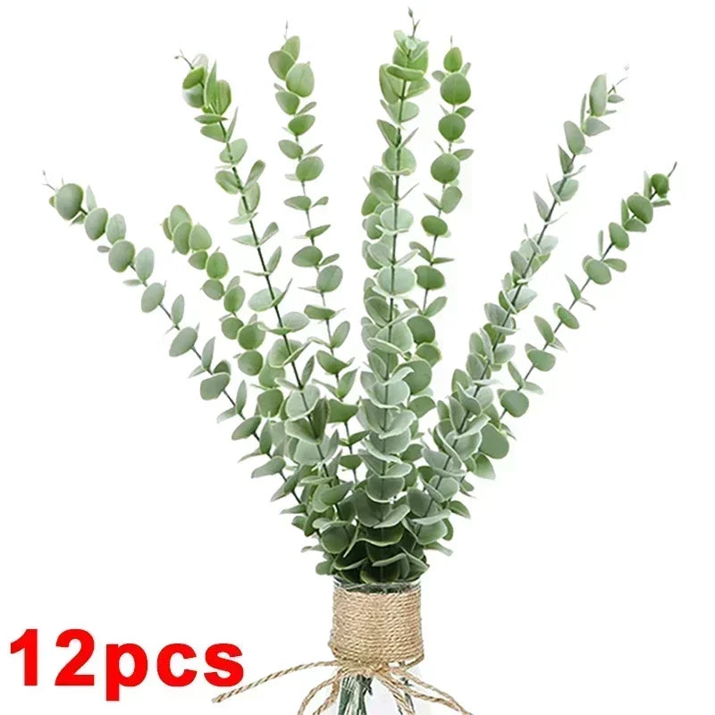 A bundle of artificial eucalyptus stems with green leaves tied together with twine.