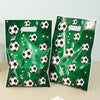 A set of green gift bags with soccer-themed graphics and banners for a party.