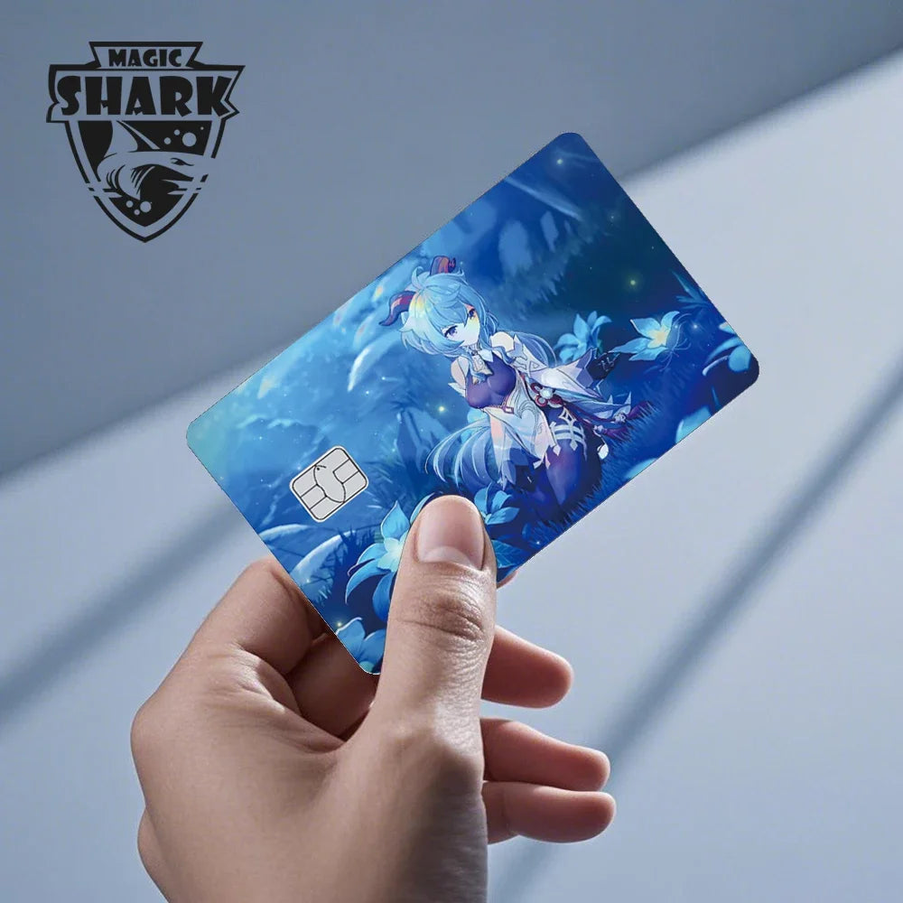A hand holds a holographic cat credit card skin sticker featuring an anime character in a blue and white background.