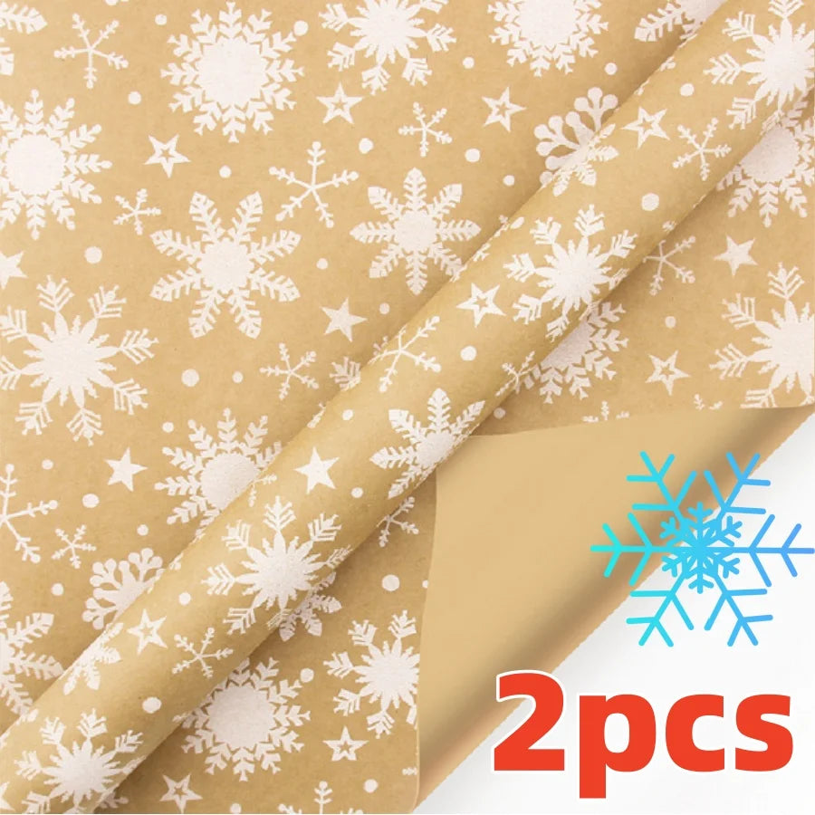 Two rolls of festive snowflake Christmas wrapping paper on brown paper.