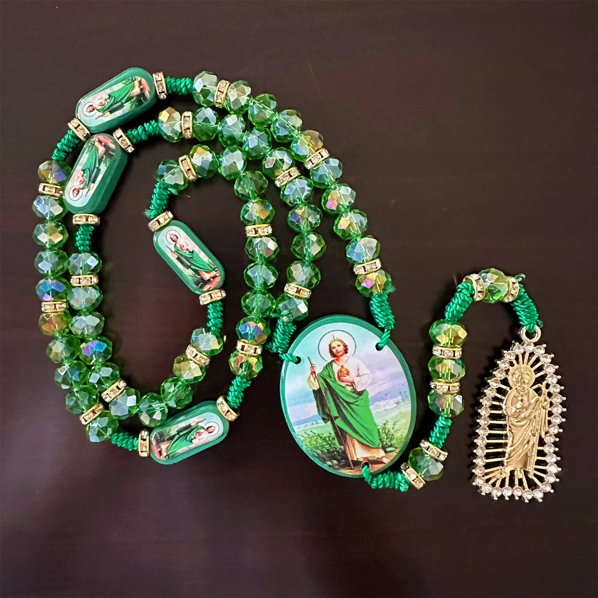 Green crystal rosary necklace featuring a Saint Jude and Virgin Mary cross pendant.