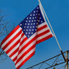A large 3x5 foot American party bunting flag waving against a clear blue sky.