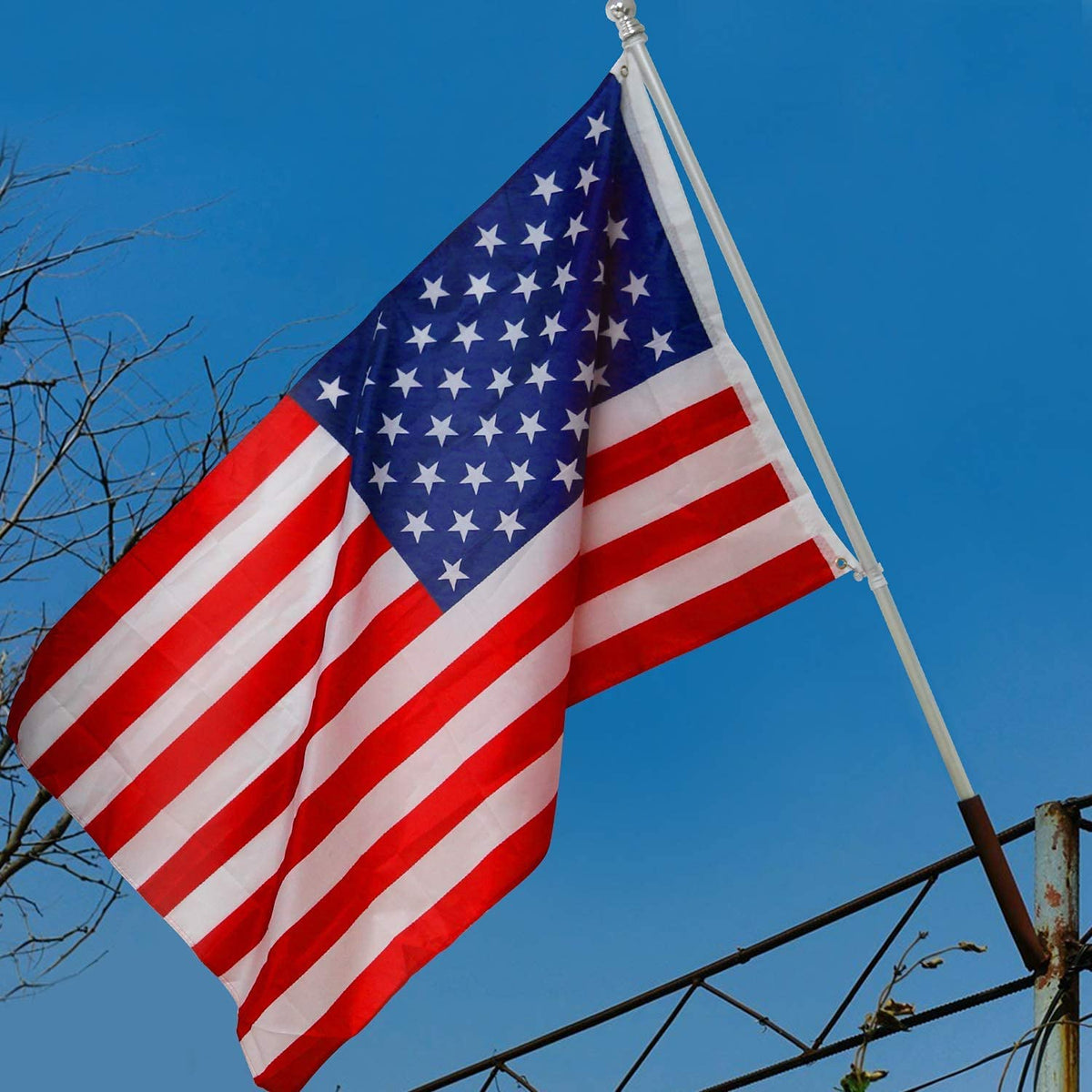 A large 3x5 foot American party bunting flag waving against a clear blue sky.