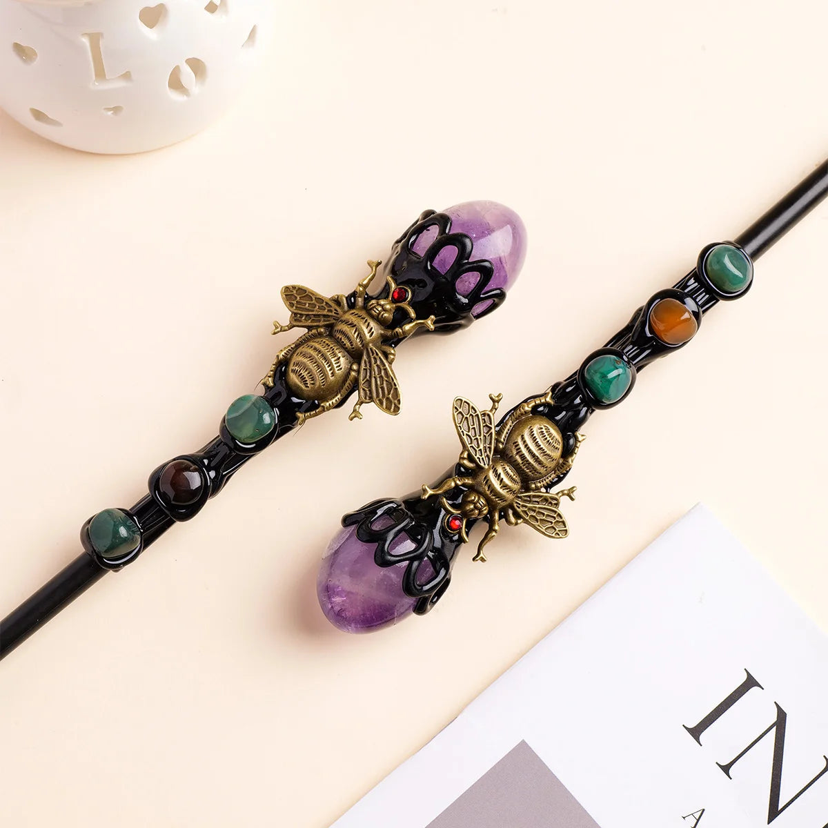A golden bee crystal scepter featuring purple amethyst beads and a dark shaft.