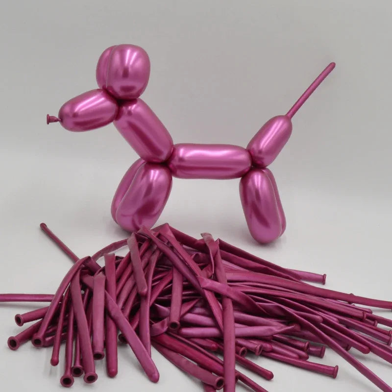 A pink latex modeling balloon shaped like a figure is shown next to a pile of similar pink balloons.