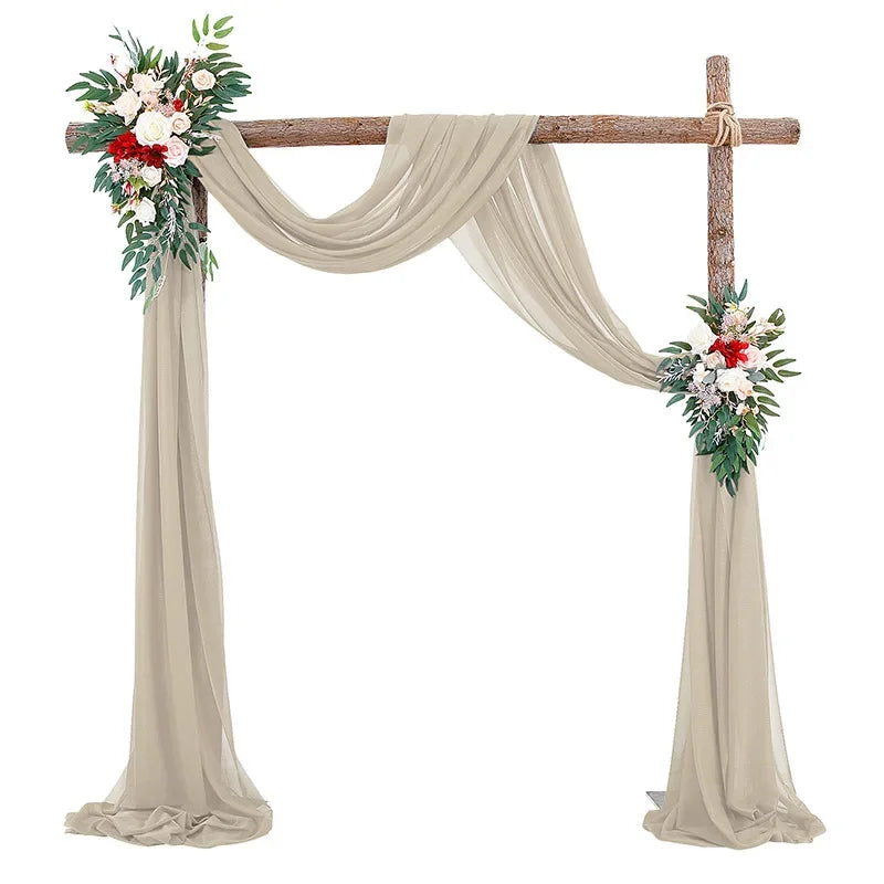 Elegant chiffon arch drapes with floral accents used as a wedding or event backdrop.