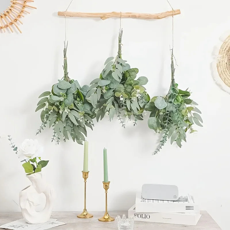 A display of mixed eucalyptus and willow artificial flower bouquets hanging on a wooden rack.