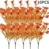 A bunch of artificial autumn bouquet featuring vibrant orange and yellow silk flowers on thin stems.