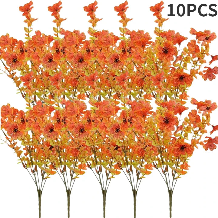 A bunch of artificial autumn bouquet featuring vibrant orange and yellow silk flowers on thin stems.