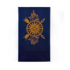 A dark blue velvet card featuring a gold-colored tarot symbol with crossed swords and foliage.